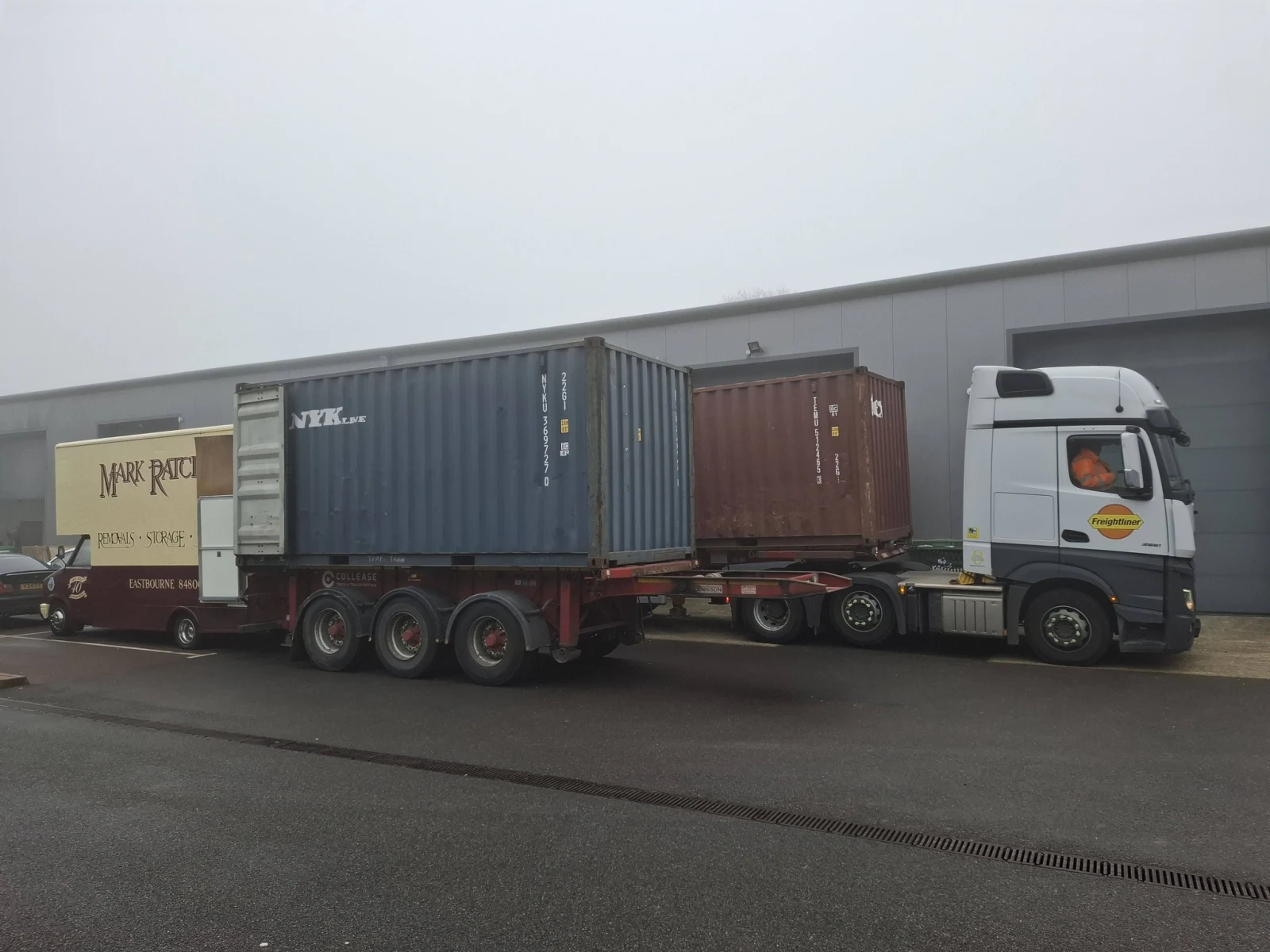 Two 20ft shipping containers on a low-loader next to a Mark Ratcliffe Eastbourne pantechnicon