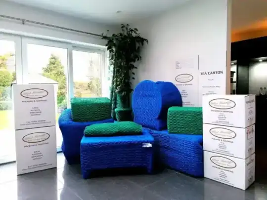 Furniture individually pad-wrapped in heavy quilted blankets before leaving the room
